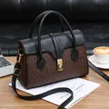 Elegante borsa tote vintage con monogramma e patta in pelle su scrivania in legno - Nero