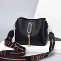 Black leather bucket bag with gold tassel and wide LOVE letter print shoulder strap - Black