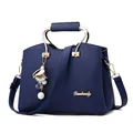 Dunkelblaue Handtasche aus Kieselleder mit goldenen Rundgriffen und Perlenanhängern - Blau
