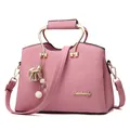 Pink lychee grain faux leather handbag with gold logo and floral charm details - Pink