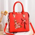 Red embroidered handbag for women with floral patterns and a butterfly pendant accessory - Red