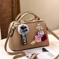 Borsa a mano beige scuro con fiori 3D, trama in pelle e ciondolo in peluche grigio - Cachi