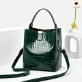 Dunkelgrüne Eimer-Tasche mit Kroko-Prägung, Tragegriff und verstellbarem Schultergurt - Grün