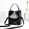Glänzende schwarze Eimer Tasche mit Krokodilmuster, Goldteilen und langem Schultergurt - Schwarz