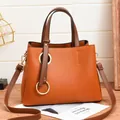 Chic caramel brown PU leather handbag with contrasting dark handles and golden ring detail - Earthy Yellow