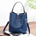 Dark blue crocodile pattern bucket bag in shiny patent leather with gold hardware - Blue