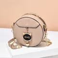 Beige round crossbody bag with quilted leather, chain strap, and cat charm detail - Khaki