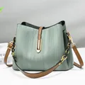 Elegante borsa a secchiello verde menta con trama a onde, bordi marroni e catena oro - Verde