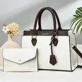 Detail of cream tote bag and matching clutch with dark brown handles in home setting - Off White