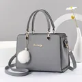 Bolso de mano en cuero PU gris con logo Danbaoly dorado y colgante de pompón blanco - Gris
