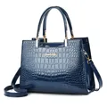 Sac à main en cuir verni bleu foncé avec motif crocodile et détails métalliques - Bleu