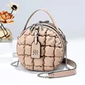 Detail der beigen gesteppten Rundtasche mit Blasenstruktur und goldener Kette - Khaki