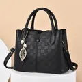 Classic black faux leather handbag with quilted texture and leaf pearl charm detail - Black