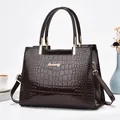 Vue détaillée du sac à main marron foncé à motif crocodile avec garniture dorée - Café