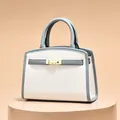 Modische zweifarbige Handtasche in Weiß und Graublau mit goldenem Schloss und Griffen - Gebrochenes Weiß