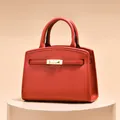 Klassische rote Lederhandtasche mit feiner Narbung und blassgoldenem Drehverschluss - Rot
