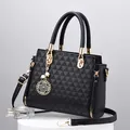 Elegante schwarze Handtasche mit geometrischer Textur und goldenen Akzenten und Perlen - Schwarz