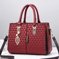 Bolso burdeos acolchado con forma de ala, colgante de hoja y detalles dorados - Rojo