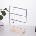 Détail d'un présentoir à boucles d'oreilles en métal argenté avec socle en bois - Argent 66 Trous