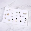 Collection of golden jewelry with pearls and gems on a professional white display grid - White