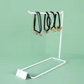 Three premium elastic hair ties with gold clover and flower charms on a white metal stand - Single Row / White