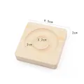 Detailed view of square wooden jewelry display tray with concentric grooves and natural grain - Square