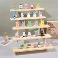 Macro view of 25 mini cartoon resin figures displayed on a 5-tier wooden trapezoid stand - 5-Tier