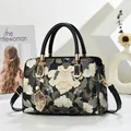Borsa a mano con ricami floreali, manici in pelle e ciondolo a foglia con perle d'oro - Nero