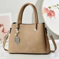 Stijlvolle beige handtas met verticale textuur en elegant parel- en bladbedeltje detail - Khaki