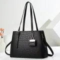 Black crocodile embossed tote bag with mini pouch pendant on a modern white background - Black