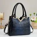 Detailed view of crocodile pattern gradient patent leather bag with gold V-shaped hardware - Blue