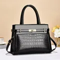 Elegant black crocodile-patterned tote bag with golden hardware and adjustable strap - Black