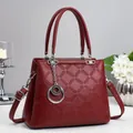 Borsa bordeaux in pelle goffrata con finiture argentate in un set fotografico curato - Borgogna