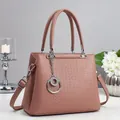 Elegant dusty pink crossbody handbag with geometric embossing and silver hardware accents - Pink