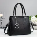 Fashionable black textured leather handbag with dual handles and silver ring ornament - Black