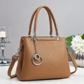 Close-up of brown tote bag showing geometric embossed texture and silver chain detail - Dark Khaki