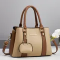 Detail view of contrast color handbag with lychee pattern leather and gold hardware - Khaki Color-Block