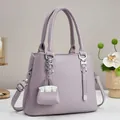 Elegante lavendelpaarse leren handtas met lychee-patroon en bijpassende mini-tasbedel - L25 H20 B11 / Paars