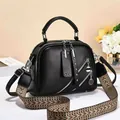 Black pebbled leather handbag with silver zippers and ethnic style woven strap - Black