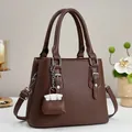 Detail of dark brown lychee pattern leather tote bag with silver hardware and pendant - 25cmx20cmx11cm / Coffee