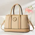 Detail of beige woven tote bag with faux leather trim and gold metal G-logo - Khaki
