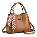 Caramel brown bucket bag with lychee texture, top handle, and patterned silk scarf - Earthy Yellow