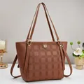 Detail of brown tote bag with checkered embossing and elegant gold logo hardware - Earthy Yellow