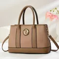Brown spliced leather tote bag with G-shaped metal ornament and dual top handles - Brown