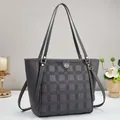 Detail of grey checkerboard tote bag with embossed textures and gold-tone logo hardware - Gray