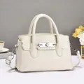 Crèmewitte crossbodytas met lycheetextuur, ronde handgrepen en zilverkleurig metalen slot - Broken Wit