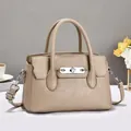 Detail van kaki crossbodytas van generfd leer met zilveren hardware en handvatten - Khaki