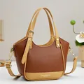 Brown and beige contrast leather handbag with adjustable strap in a minimalist setting - Earthy Yellow