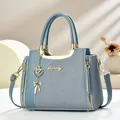 Elegante Morandi-blaue Handtasche mit goldenen Beschlägen auf einem minimalistischen Podest - 24x12x19cm / Blau