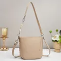 Dettaglio della borsa a secchiello beige con cuciture a U e catena in corda intrecciata - Cachi
